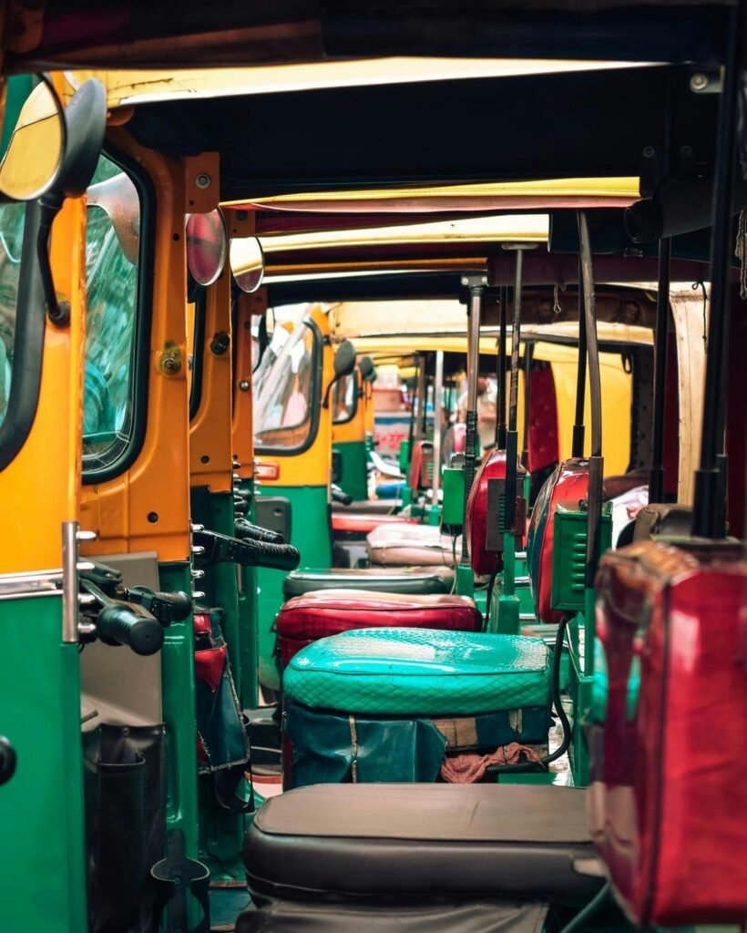 Vibrant auto rickshaw interiors aligned in a close urban street setting, showcasing bright colors and unique design.